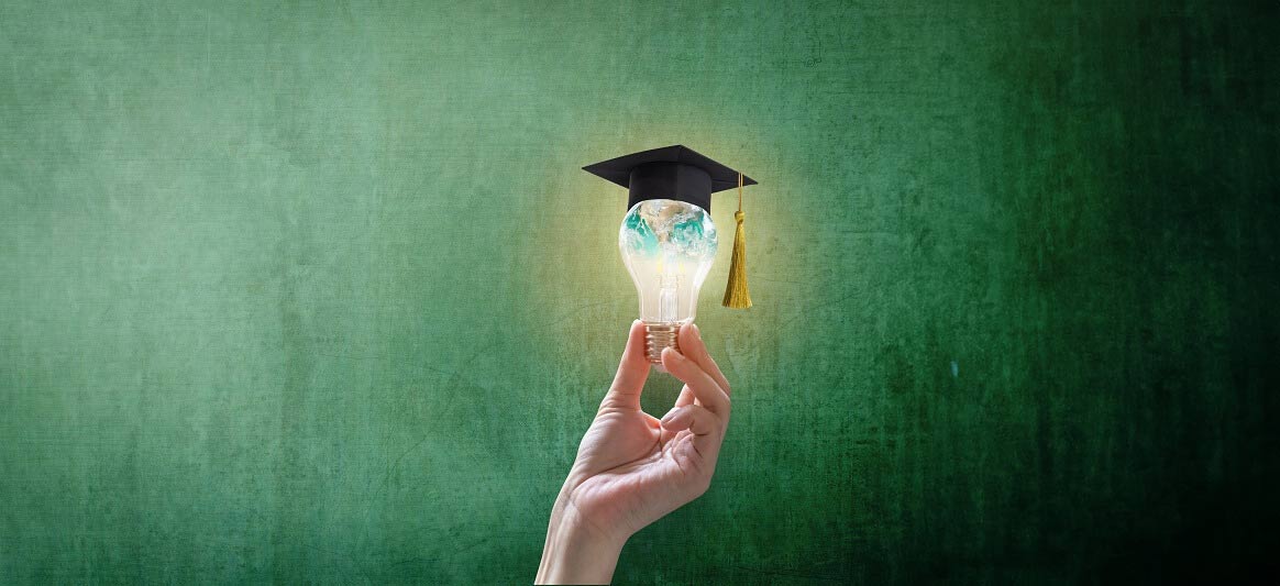 Una mano regge una lampadina con dentro il globo, sormontata dal tocco della laurea